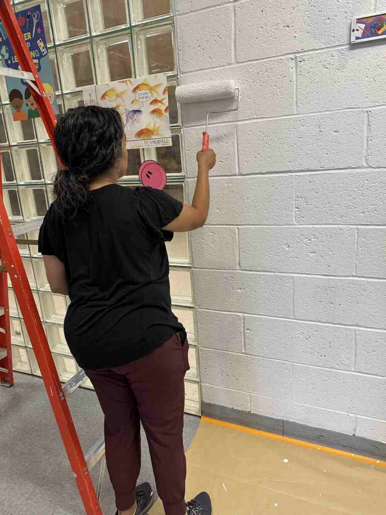 Women United member painting a wall