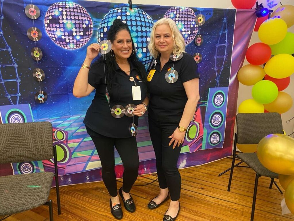 2 women posing at the photo wall at the Motown Memories event at the Hispanic Center in Bethlehem