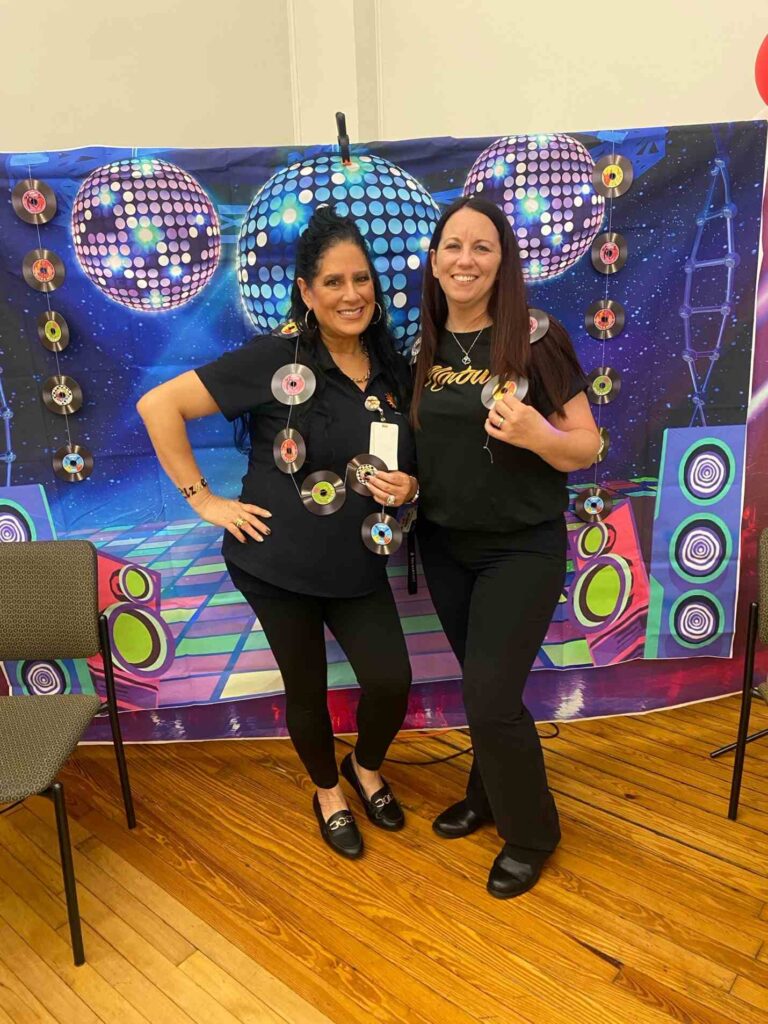 2 women posing at a photo wall at the Motown Memories event at the Hispanic Center in Bethlehem