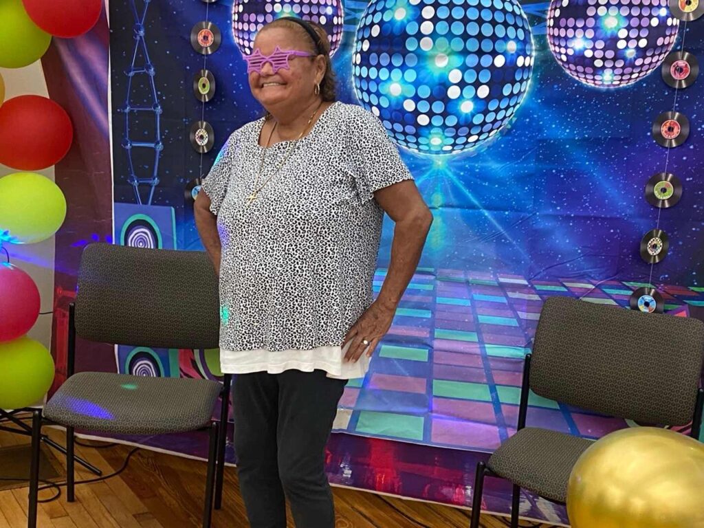 Female attendee posing in front of photo wall