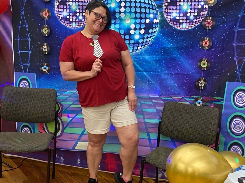 Female attendee posing in front of photo wall