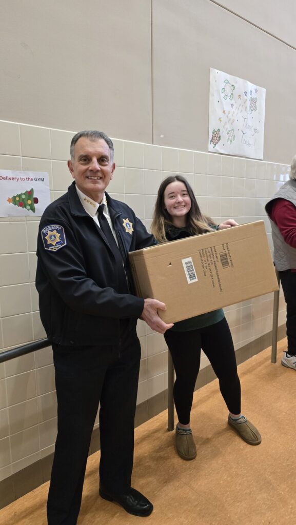 2 volunteers at Roosevelt Elementary School in Allentown unpacking presents during the 2024 TeenWorks Toy Drive