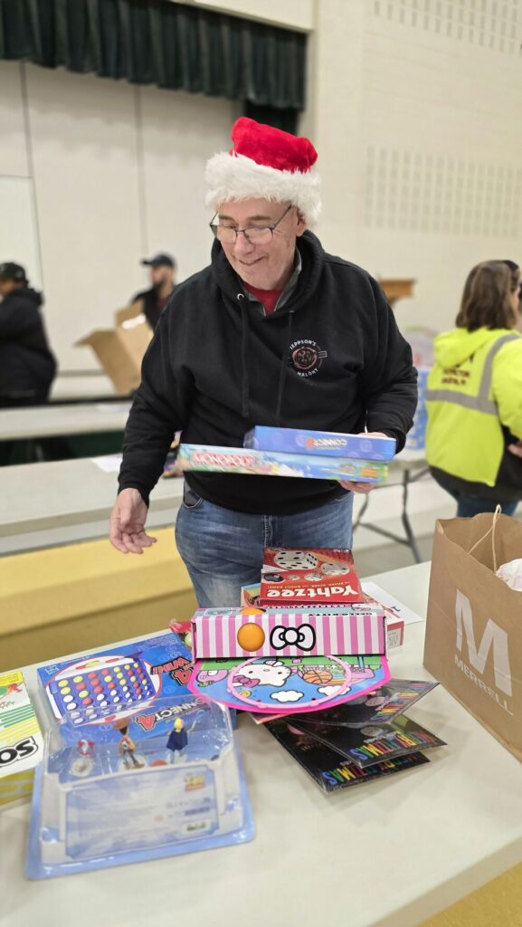 Gregg Potter from Capital Blue Cross at Roosevelt Elementary School in Allentown unpacking presents during the 2024 TeenWorks Toy Drive