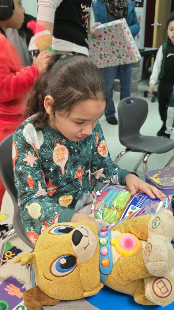 Child opens present at Roosevelt Elementary School