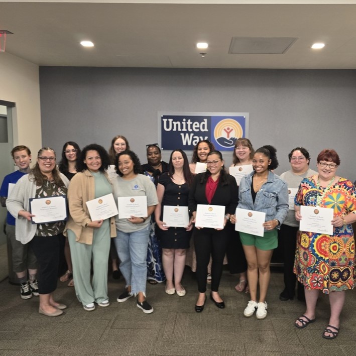AmeriCorps members group shot holding up their certificates -cropped
