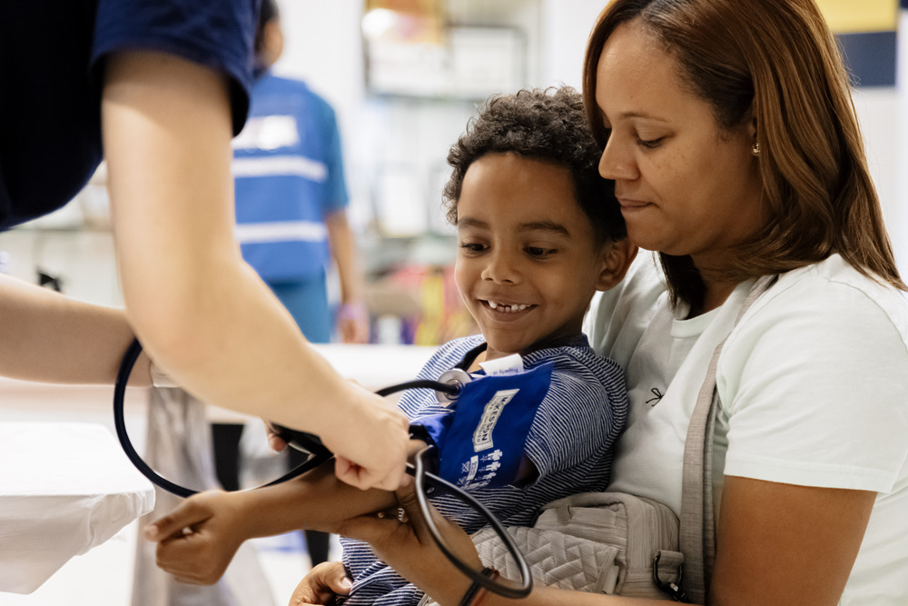 Global Hope International young boy getting blood pressure checked on mother's lap