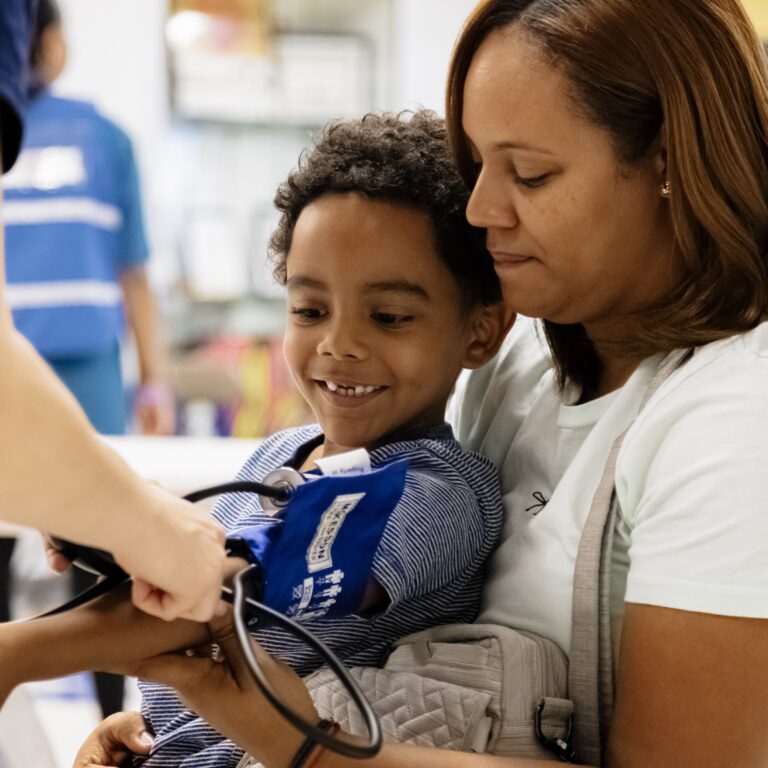 Global Hope International young boy getting blood pressure checked on mother's lap