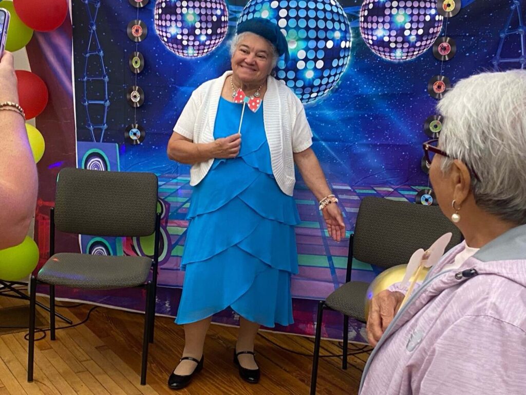 Female attendee posing in front of photo wall