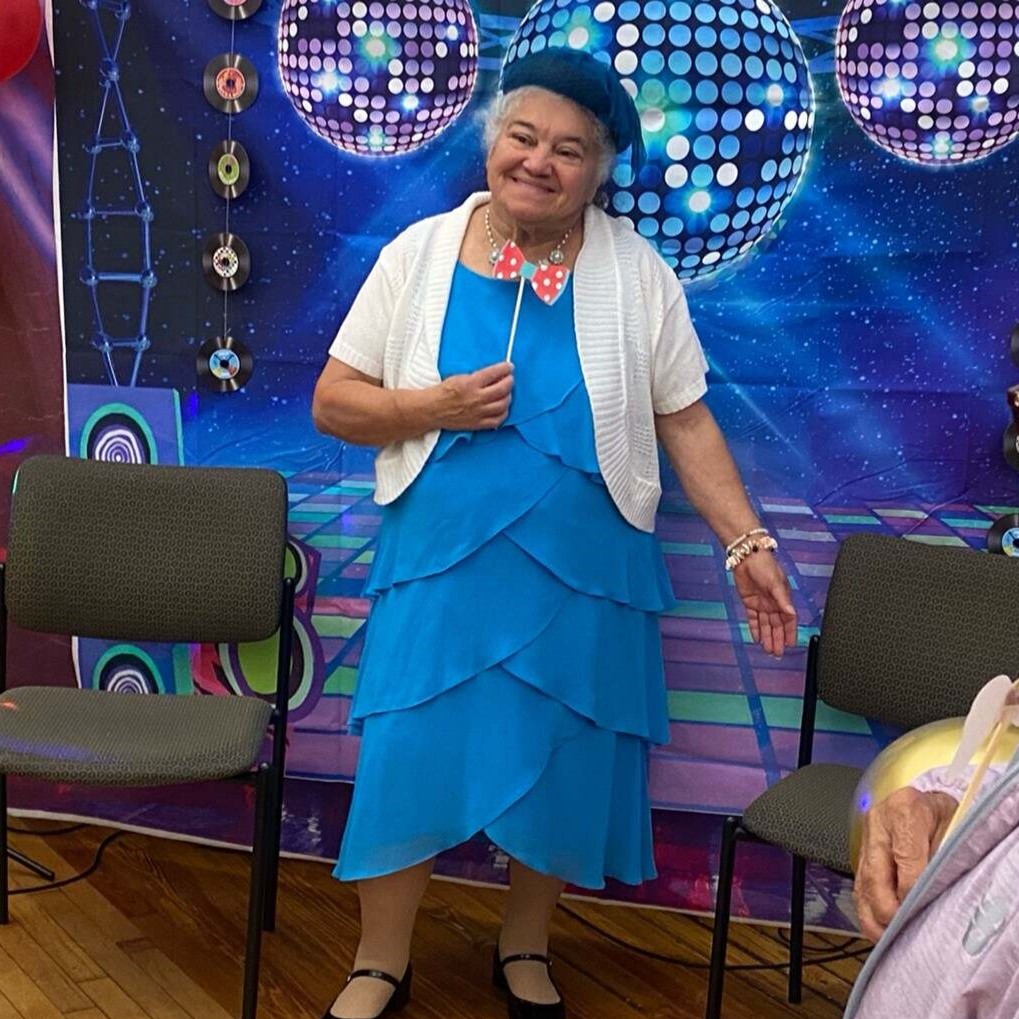 Female attendee posing in front of photo wall