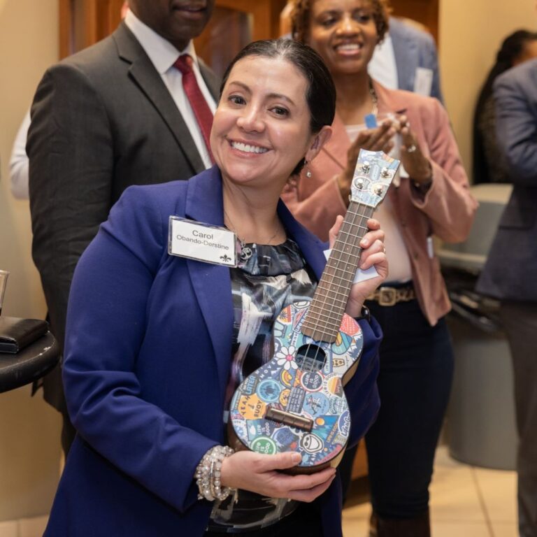 Carol holding a Life is Good Martin Guitar Uke at the Tocqueville Winter Welcome